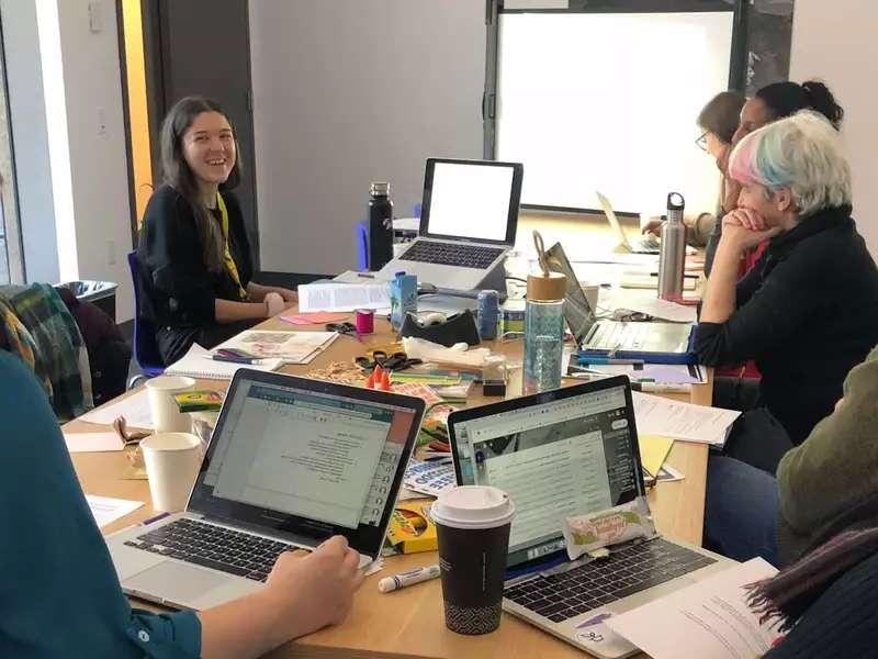 Students around a conference table with open laptops